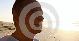 Smiling senior man standing on beach