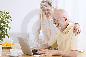 Smiling senior man using laptop