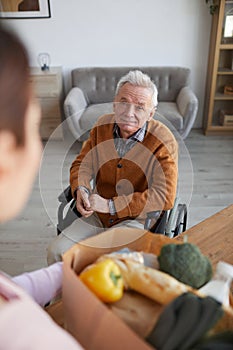 Smiling Senior Man in Wheelchair Accepting Food Delivery