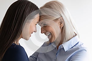 Smiling senior mom and adult daughter enjoy time together