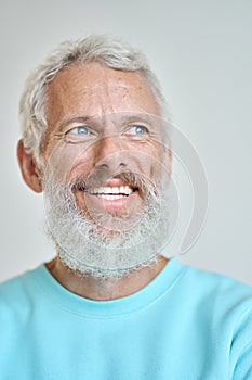 Smiling senior old man looking away dreaming isolated on white. Vertical closeup