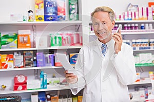 Smiling senior phoning while reading prescription