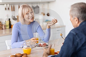 Smiling senior spouses enjoying healthy meal together