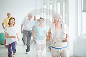 Smiling senior trainer showing exercise