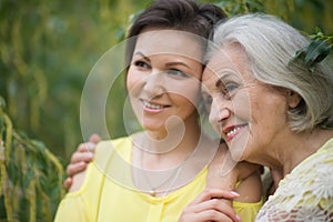 Smiling senior woman with adult daughter in autumnal park