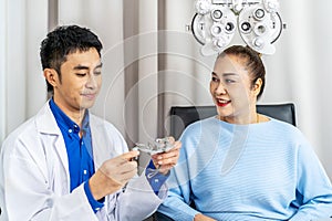 Smiling senior woman asian checking vision with eye test glasses during a medical examination at the ophthalmological office,