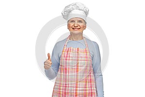 smiling senior woman or chef in toque in apron