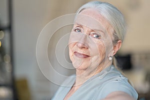 Smiling senior woman. Close up facial portrait of a beautiful senior woman with a warm friendly smile and attentive