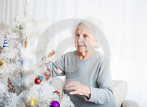 Senior woman decorating christmas tree