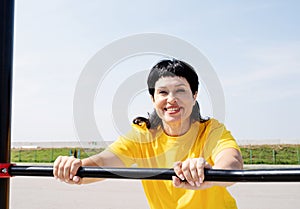 Smiling senior woman doing push-ups outdoors
