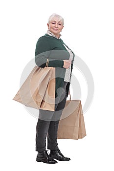 Smiling senior woman with shopping bags over white background