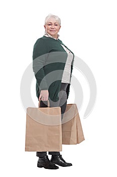 Smiling senior woman with shopping bags over white background