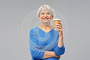 Smiling senior woman with takeaway coffee cup