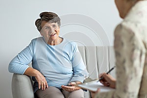 Smiling senior woman talking to a psychologist about happy life photo