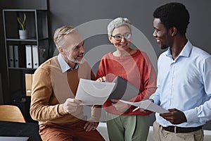 Smiling senior workers collaborating on project