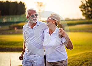 Smiling seniors golfers couple