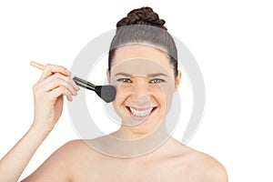 Smiling sensual model using blusher brush