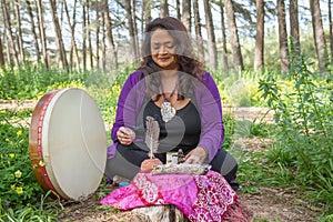 Smiling shaman woman with drum seated at altar