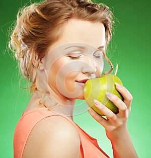 Smiling sharming woman with green apple over green background