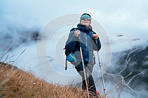 Smiling Sherpa men in sunglasses backpacker with trekking poles hiking and enjoying Mera peak climbing acclimatization walk on