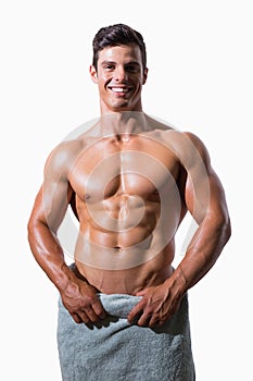 Smiling shirtless muscular man wrapped in white towel