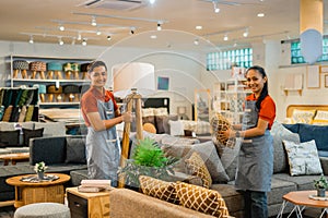 smiling shop assistants with a friend working to tidy up a store