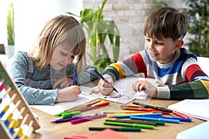 Smiling sibling doing homework together