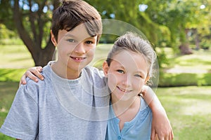 Smiling sibling looking at camera in the park