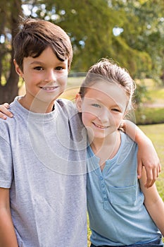 Smiling sibling looking at camera in the park