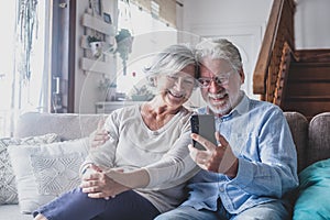 Smiling sincere mature older married family couple holding mobile video call conversation with friends, enjoying distant