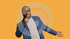 Smiling singer holding microphone, performing tunes, studio background