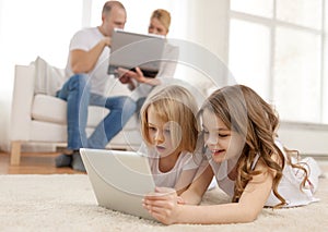 Smiling sister with tablet pc and parents on back