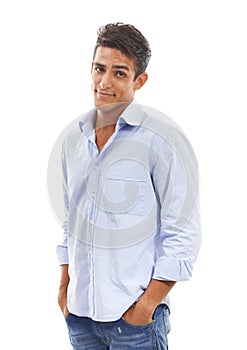 Smiling skepticism. Portrait of a handsome young man standing with hands in his pockets against a white background.
