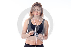 Smiling slender girl standing right and holding water bottle