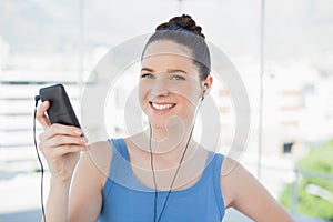 Smiling slender woman listening to music