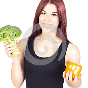 Smiling slim woman holding peppers and broccoli . Diet and proper nutrition . Vegetarian food