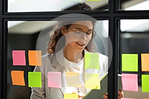 Smiling smart businesswoman using kanban agile scrum method glass board.