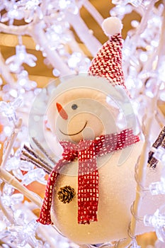 Smiling snowman with red hat and muffler among ice crystals