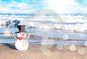 Smiling snowman at sunny beach. Holiday concept for Merry Christmas and Happy New Years cards