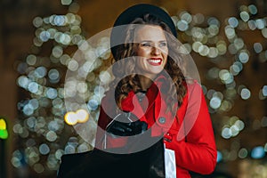 Smiling solo traveller woman outside in city street at night