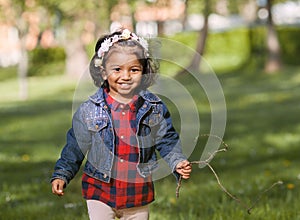 A smiling South Asian girl is playing in park