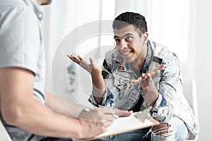 Smiling spanish teenager consulting youth problems with therapist