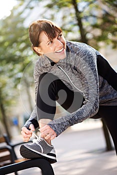 Smiling sport woman tying shoelace