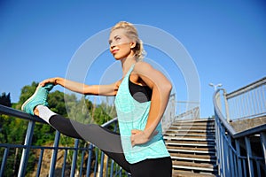 Smiling sportive woman having workout on the steps