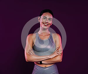 Smiling sportswoman with crossed arms wearing silver sportswear