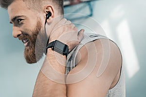 Smiling sporty man with smartwatch on wrist