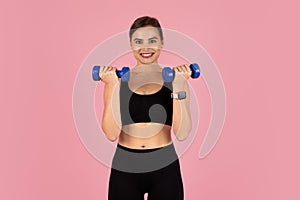 Smiling sporty woman doing fitness routine, training with blue dumbbells