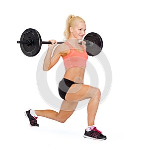 Smiling sporty woman exercising with barbell