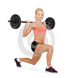 Smiling sporty woman exercising with barbell