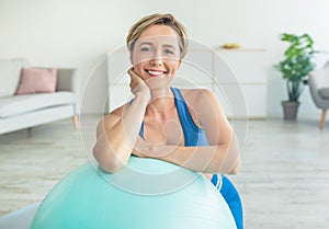 Smiling Sporty Woman Exercising Leaning On Fitness Ball At Home